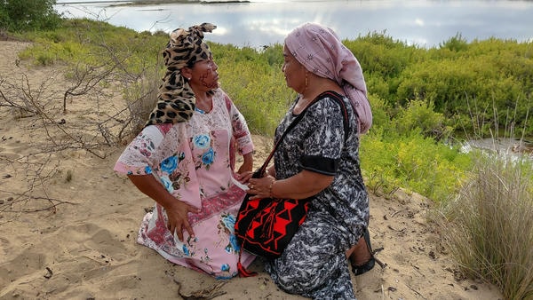 Donne Wayuu nel deserto della Guajira, una indossa una mochila tradizionale fatta a mano