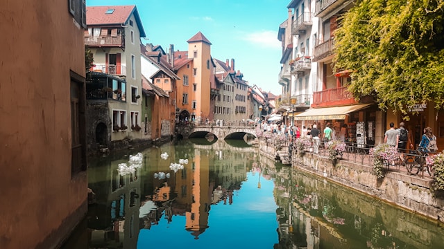 Edifici si affacciano e rilettono sull'acqua di un canale di Annecy