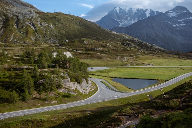 Paesaggio montano del Passo del Sempione con prati e una strada panoramica