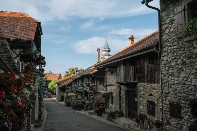 Vicolo caratteristico dove sui lati si affacciano edifici in pietra decorati da dettagli floreali a Yvoire