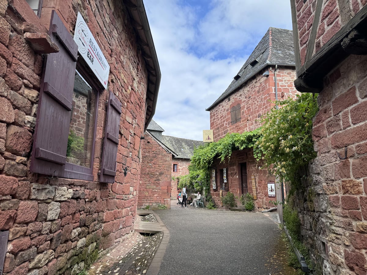 Strada con edifici di mattoni rossi ai lati a Collonges-la-Rouge in Francia