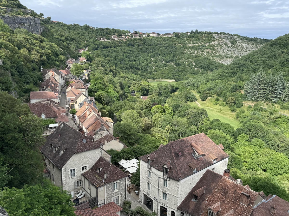 Vista dall'alto sul borgo medievale di Rocamadour, circondato da prati verdegginanti