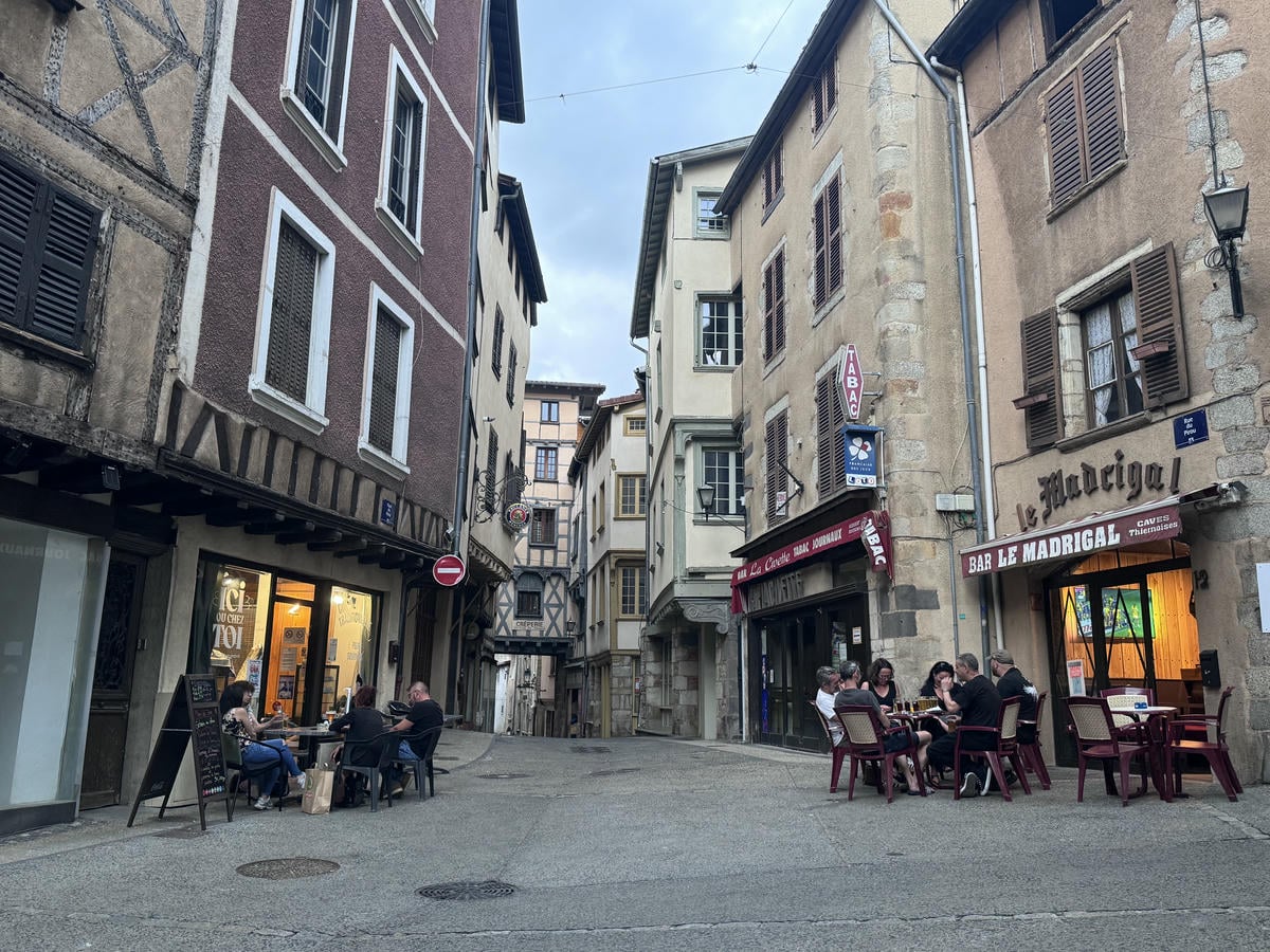 Vicolo con bar e un ristorante con persone sedute ai tavoli a Thiers