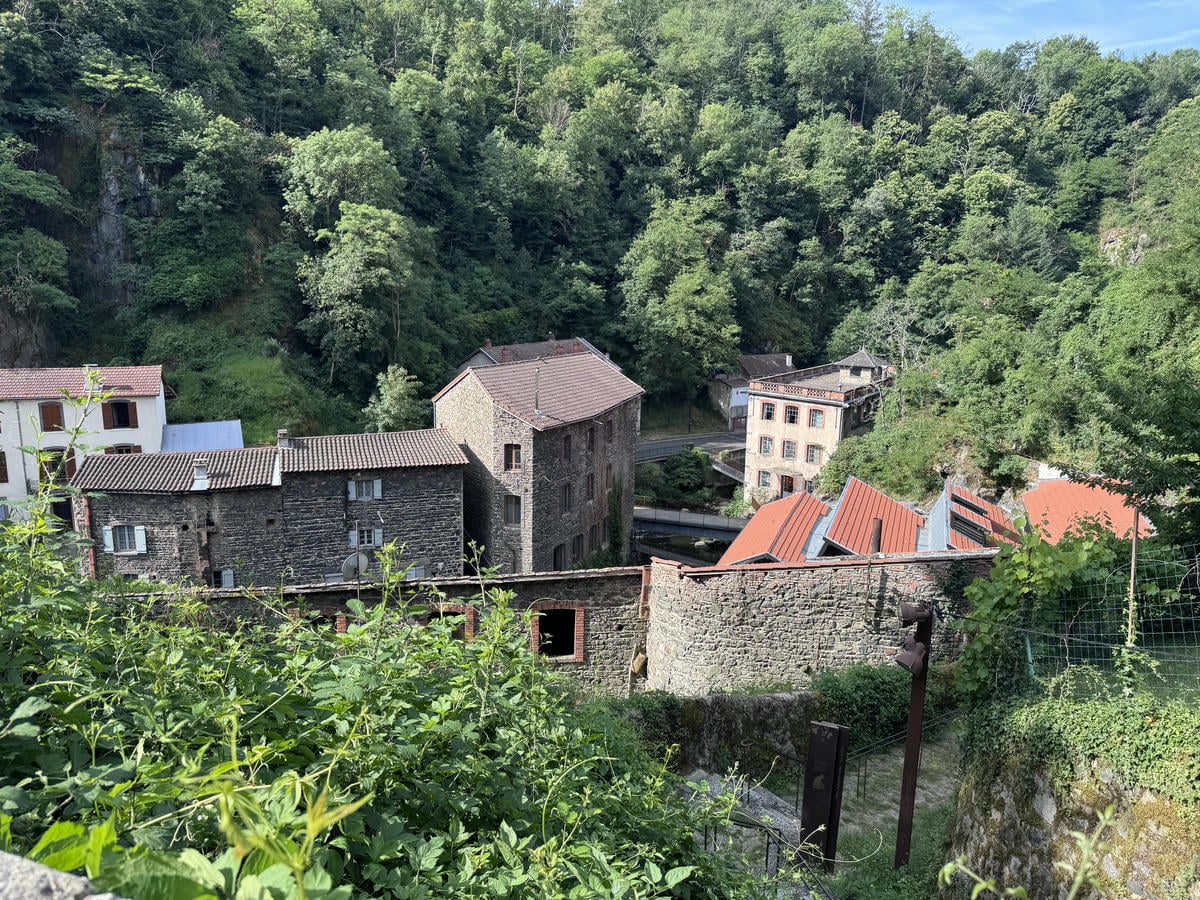Edifici lungo il fiume La Durolle circondati da prati verdi  a Thiers