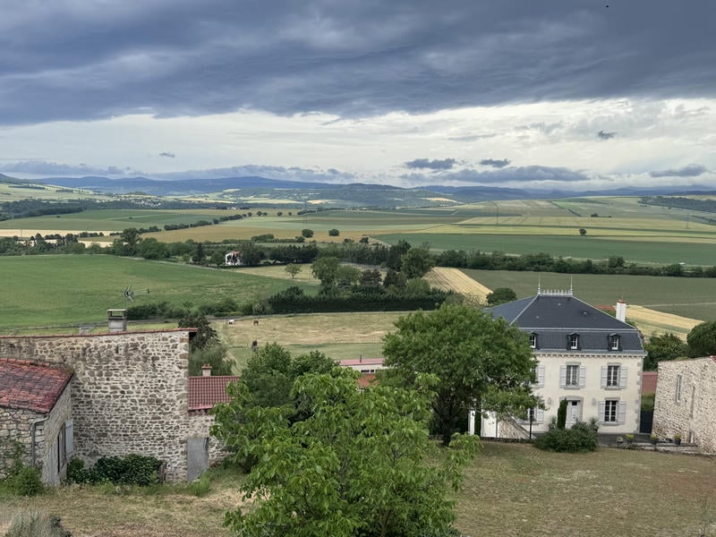 Panorama da Montpeyroux sulla valle dei vulcani con prati verdi