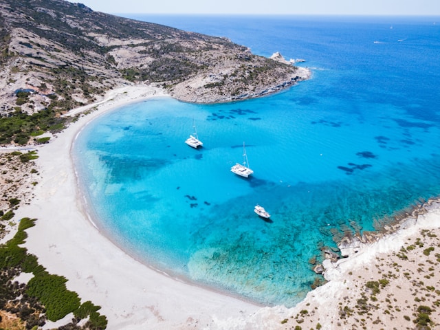 Vista dall'alto su una spiaggia con sabbia bianca e mare cristallino dell'isola greca di Milos, nell'arcipelago delle Cicladi