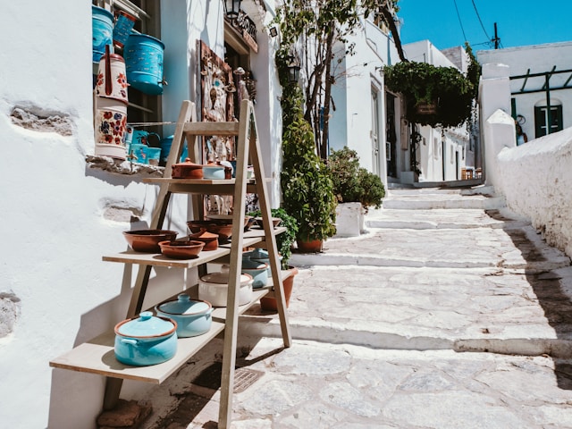 Vicolo con scalinata e negozio di souvenir con ciotole e pentole ad Amorgos, Cicladi, Grecia.