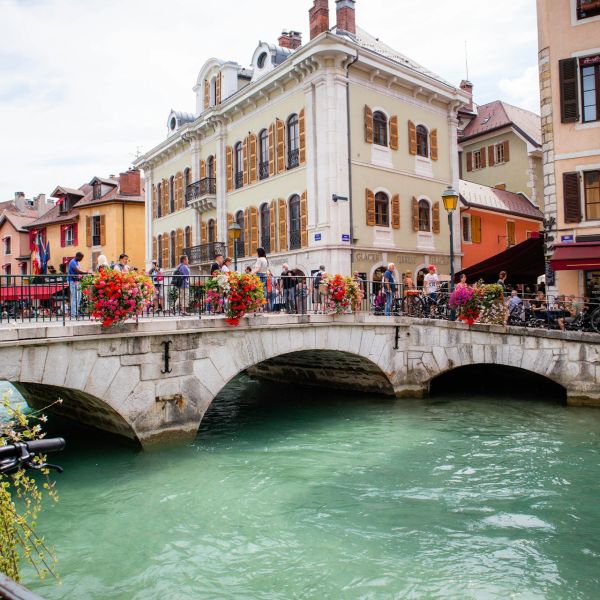 Persone che si affacciano sul ponte di un canale di Annecy, in Francia