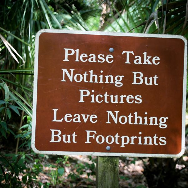 cartello con frase 'Please Take nothing but pictures, leave nothing but footprints'